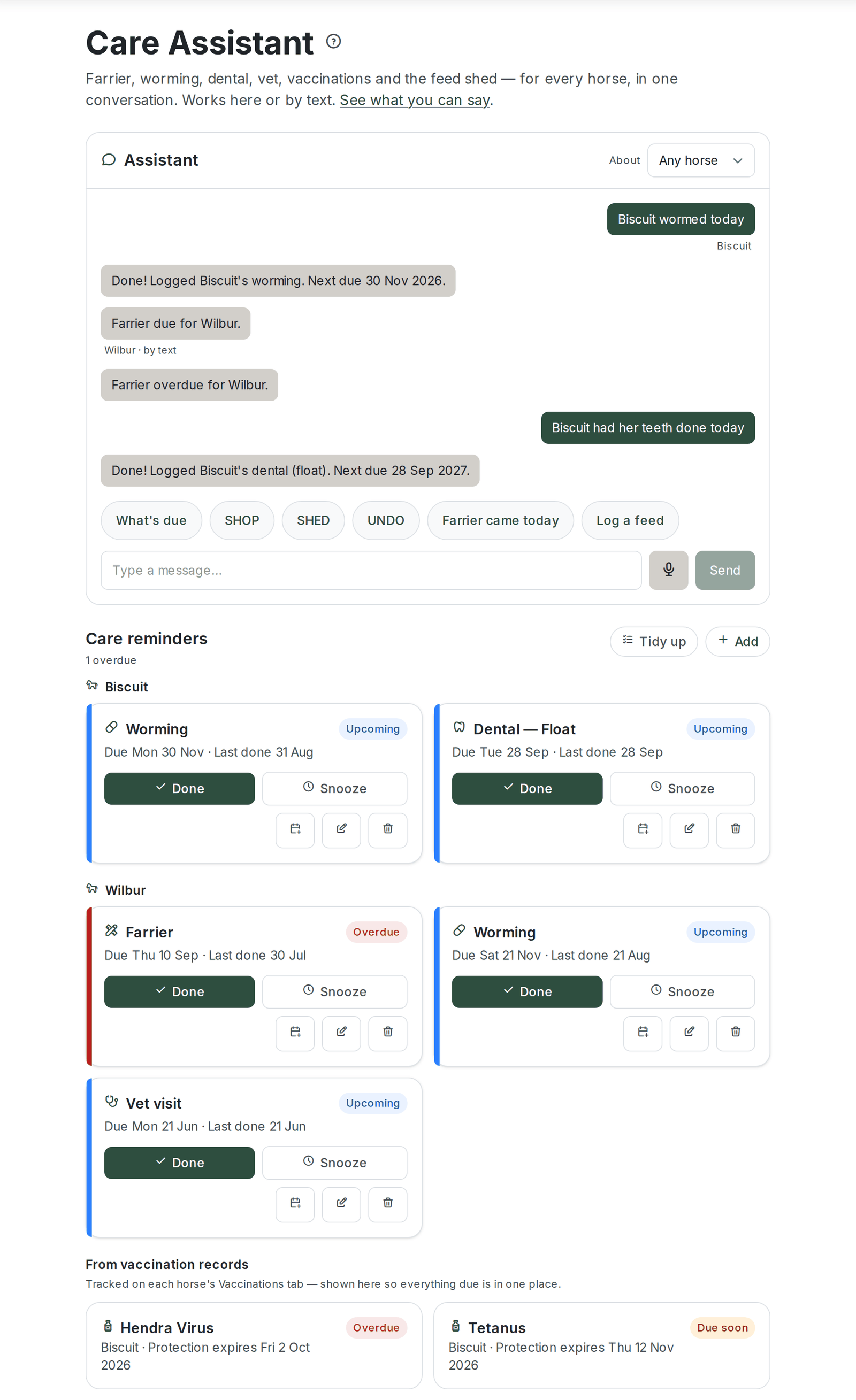 The Care Assistant page. The heading "Care Assistant" with a line saying it covers farrier, worming, dental, vet, vaccinations and the feed shed for every horse, in one conversation, here or by text, and a "See what you can say" link. Below it the Assistant chat panel with an "About" horse selector set to "Any horse", a short transcript (Biscuit wormed today, then reminder texts about Wilbur's farrier) with each message labelled with the horse it was about, quick-reply chips (What's due, SHOP, SHED, UNDO, "Farrier came today", "Log a feed") and a "Type a message..." box with microphone and Send buttons. Underneath, a "Care reminders" heading reading "1 overdue" with "Tidy up" and "Add" buttons, then reminder cards grouped under each horse's name (Biscuit: Worming and Dental, Wilbur: Farrier badged Overdue, Worming and Vet visit), each with Done and Snooze buttons and log, edit and bin buttons, and a "From vaccination records" row showing Hendra Virus (Overdue) and Tetanus (Due soon)